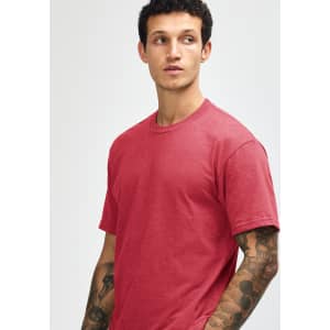 A unisex short sleeve T-shirt in a warm red colour, displayed on a model with a simple design and logo.