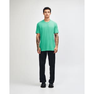 A unisex short sleeve t-shirt in vibrant green, paired with black cargo pants and styled on a male model.