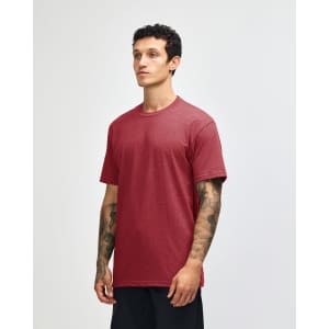 A unisex short sleeve t-shirt in a red hue, displayed on a model with a minimalistic background, featuring a logo.