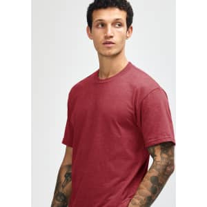A unisex CVC short sleeve t-shirt in a deep red colour, displayed on a model with a neutral background.