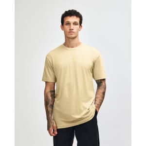 A unisex short sleeve t-shirt in a pale yellow colour, displayed on a model against a plain background.