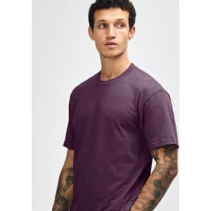 A unisex short sleeve t-shirt in a deep purple colour, displayed by a model. Features a plain design with a logo.