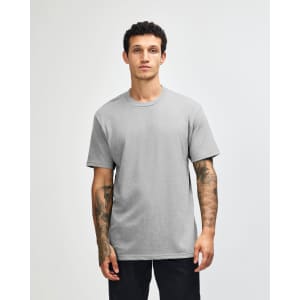 A grey unisex CVC short sleeve T-shirt on a model with a plain background, featuring a logo.