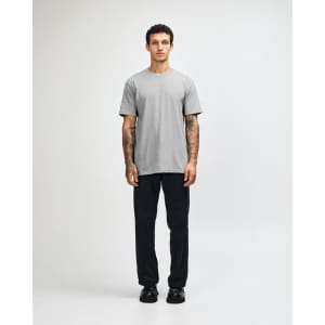 A grey unisex CVC short sleeve t-shirt worn with black cargo pants, featuring a simple design and casual fit.
