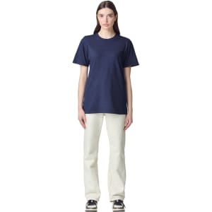 A unisex short sleeve t-shirt in navy blue, displayed on a model wearing light-coloured pants. The shirt features a logo.