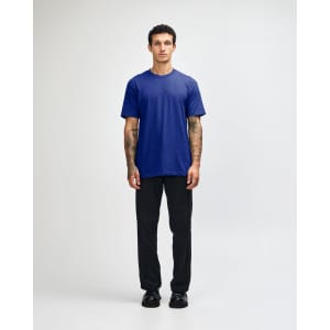 A unisex short sleeve t-shirt in blue, paired with black cargo pants, displayed on a model.