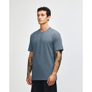 A unisex short sleeve t-shirt in a blue colour, featuring a logo on the front. The model stands against a light background.