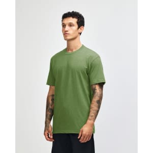 A green unisex CVC short sleeve T-shirt displayed on a model, featuring a simple design and a logo.