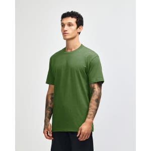 A unisex CVC short sleeve t-shirt in green, shown on a model standing sideways. Features a logo on the garment.