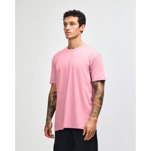 A pink unisex CVC short sleeve T-shirt displayed on a model. The shirt has a simple design and a logo.