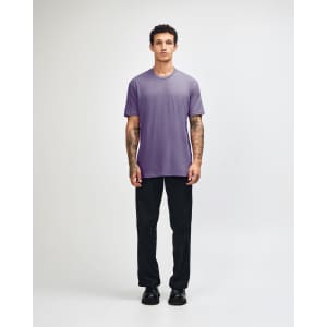 A unisex short sleeve T-shirt in purple, paired with black cargo pants. It features a logo on the shirt.