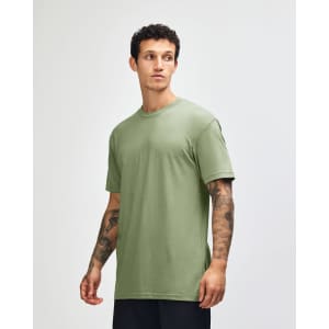 A green unisex CVC short sleeve T-shirt displayed on a model, featuring a subtle texture and relaxed fit.