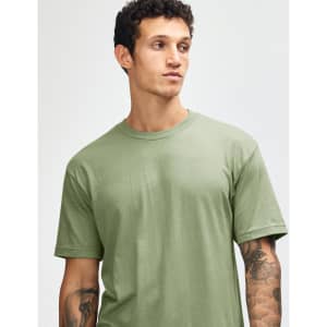 A green unisex CVC short sleeve T-shirt is displayed on a model with a neutral background. It features a logo.