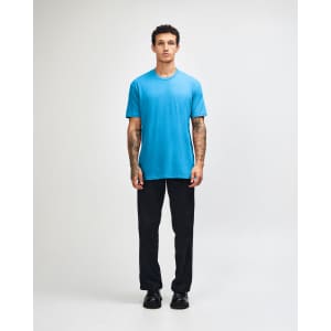 A unisex CVC short sleeve t-shirt in bright blue, worn with black cargo pants, featuring a casual style.