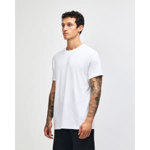A white unisex CVC short sleeve T-shirt displayed on a model, featuring a simple design and a logo.