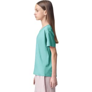 A turquoise youth t-shirt is displayed on a model standing in profile. The shirt features short sleeves and has a logo.
