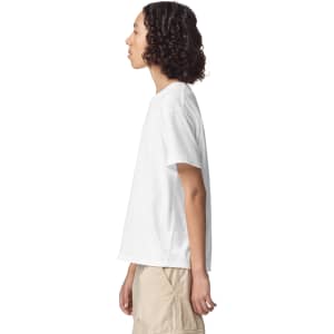 A side view of a plain white youth T-shirt with a relaxed fit, featuring a small logo.