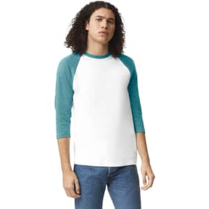 A unisex raglan t-shirt featuring a white body with teal sleeves. The model has curly hair and is wearing jeans.