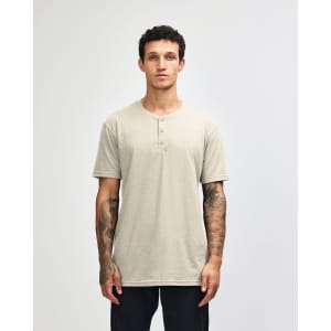 A beige unisex Henley T-shirt with short sleeves and a front placket, displayed on a male model.