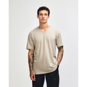 A beige unisex V-neck T-shirt made from CVC fabric, featuring short sleeves and a logo.