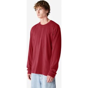 A long sleeve, fine jersey t-shirt in a deep red colour, displayed on a model wearing light blue jeans.