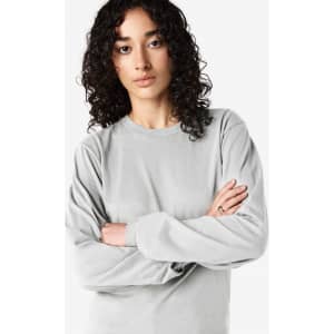 A long sleeve t-shirt in light grey, featuring a round neckline and an understated design, with a logo present.