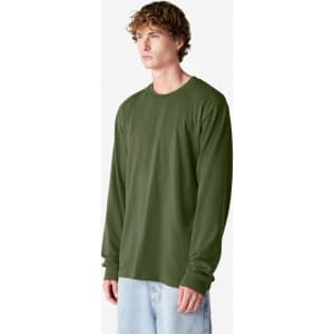 A long sleeve t-shirt in olive green, featuring a round neck and a logo. The model stands against a white backdrop.