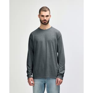 A long sleeve t-shirt in a dark grey colour, featuring a logo and worn by a man with short, styled hair.