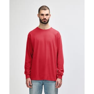 A red long sleeve T-shirt on a model standing against a plain background. The shirt features a logo.