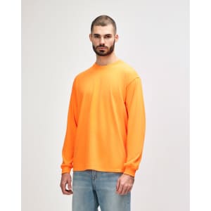 An orange long sleeve t-shirt displayed on a model, featuring a plain design and a logo.