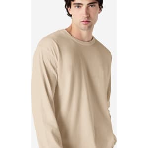 A beige long sleeve t-shirt for adults, featuring a round neckline and a fitted silhouette. It has a logo on it.