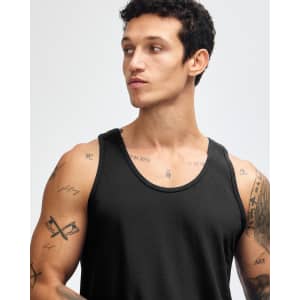A black unisex fine jersey tank top being worn by a model, featuring a logo on the fabric.