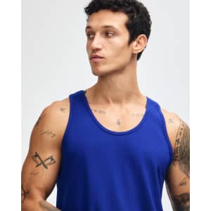 A blue unisex fine jersey tank top with a relaxed fit and no sleeves, being modelled by a person.