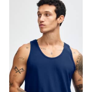 A model wearing a navy blue unisex fine jersey tank top, showcasing a relaxed fit and sleeveless design.