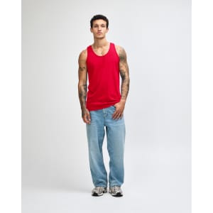 A red unisex fine jersey tank is worn by a model, paired with black cargo trousers and white sneakers.