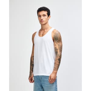A plain white unisex fine jersey tank top displayed on a model, featuring a simple design and no visible logos.