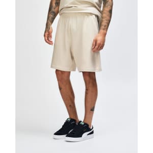 Beige unisex gym shorts with an elastic waistband and pockets, featuring a logo on the side.