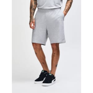 Light grey unisex gym shorts with an elastic waistband and side pockets, displayed on a model from the side.