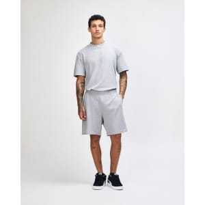 Grey unisex gym shorts with an elastic waistband and pockets, paired with black shoes and white socks.