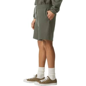 Unisex gym shorts in olive green, featuring a drawstring waist and side pockets, paired with casual shoes and socks.
