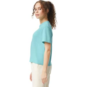 A turquoise women's heavyweight boxy T-shirt, featuring a simple design and a logo on the side.