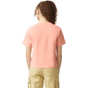 A lightweight, boxy women's t-shirt in a peach shade, featuring a plain back and a simple design.