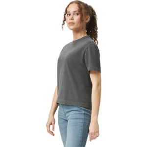 A boxy women's t-shirt in charcoal grey, featuring a logo on the front, styled with jeans.