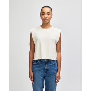 A cream-coloured women's muscle T-shirt with a relaxed, sleeveless design, featuring a logo.