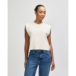 A cream-coloured muscle T-shirt with a relaxed fit and no sleeves, featuring a small logo.
