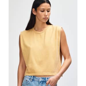A muscle t-shirt in a soft yellow hue, featuring a crew neck and wide armholes. The shirt has a logo on it.