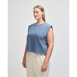 A sleeveless, cropped muscle t-shirt in deep blue, featuring a simple design and a logo.