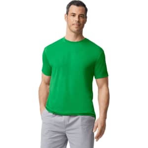 A man wearing a bright green Gildan Performance adult T-shirt and light grey shorts. The T-shirt has a logo.