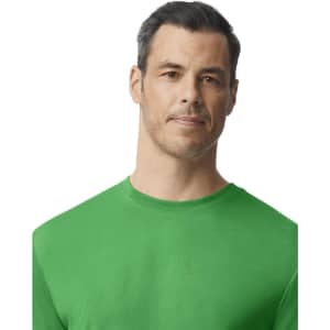 A green Gildan performance adult T-shirt displayed on a model with a neutral expression. The shirt features a logo.