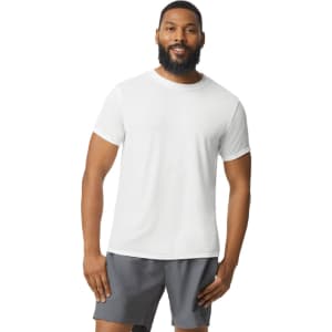 A white Gildan Performance adult t-shirt displayed on a model, paired with grey shorts and featuring a logo.